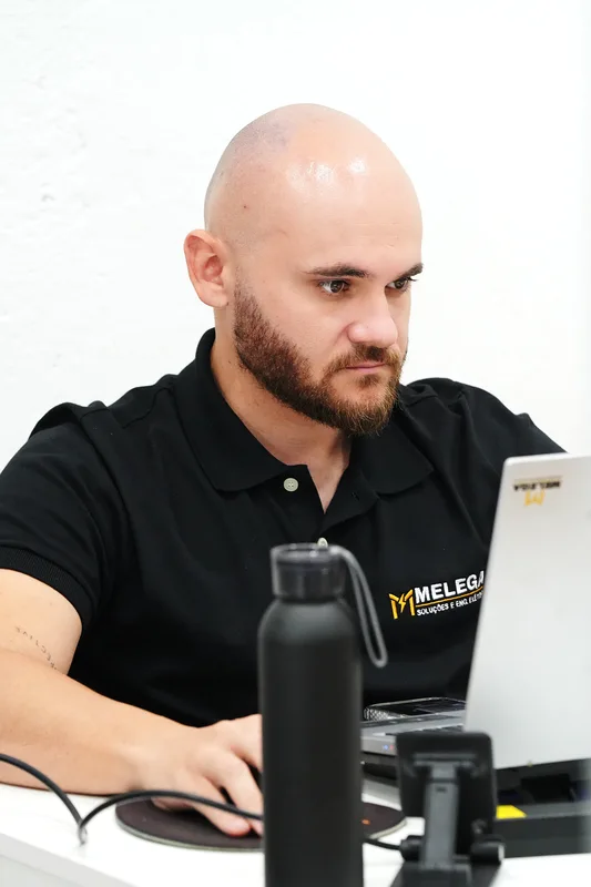 Profissional da Melega trabalhando no computador no escritório